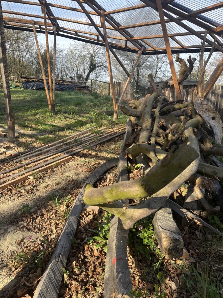Waldgarten Kunstwerk Holzstapel